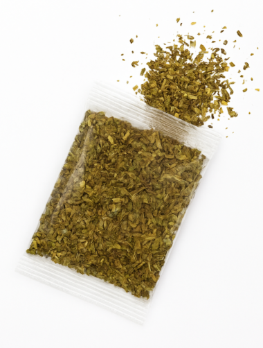 A white bowl filled with vibrant Italian seasoning, showcasing its colorful blend of herbs and spices.