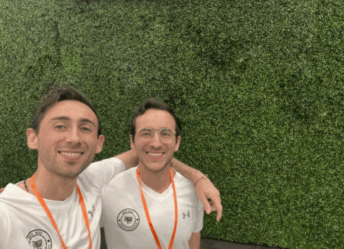 Two Despensa Colombiana team members smiling at a trade event, representing business partnerships and collaboration