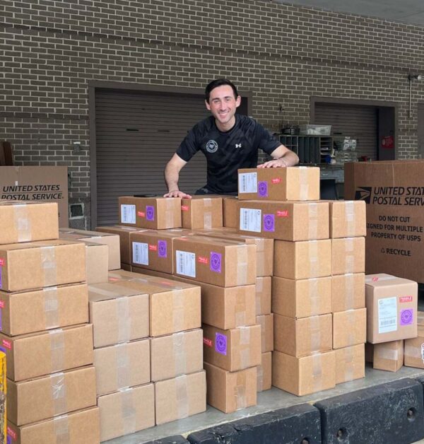 Workers organizing and loading cardboard packages in a warehouse dock for shipping and distribution